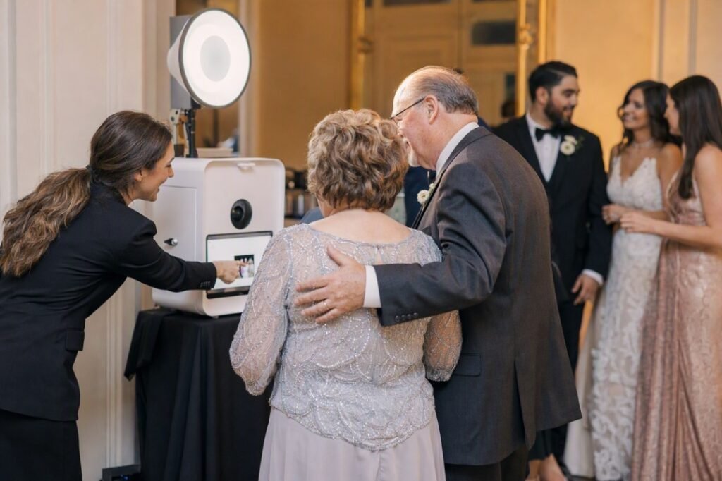 Photo booth attendant assisting guests at a wedding reception